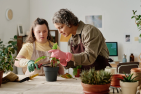 A woman helping a girl with Down Syndrome water a plant
